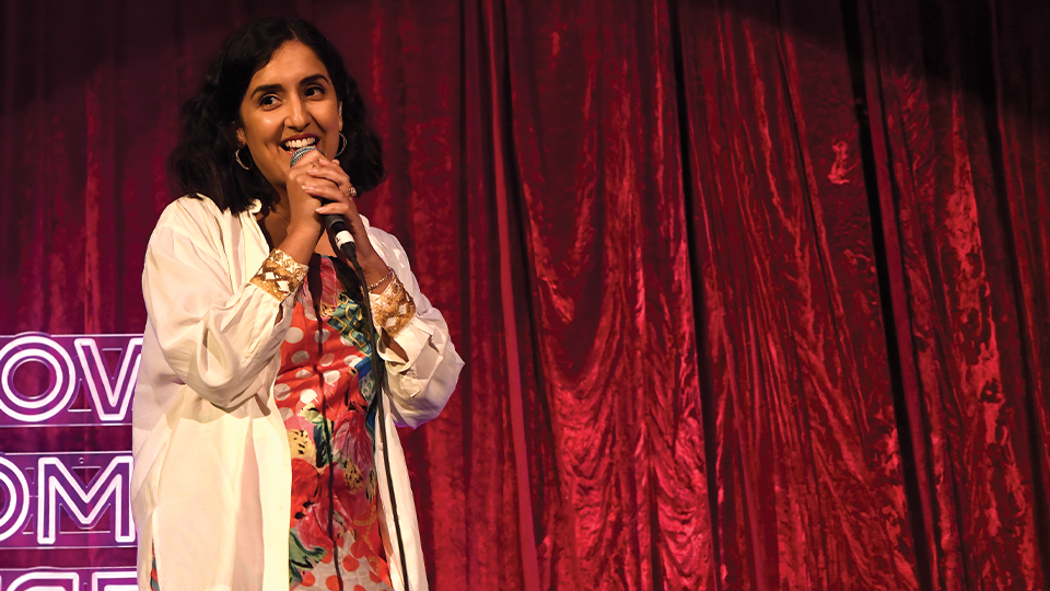 Daizy Mann on stage at a comedy gig.