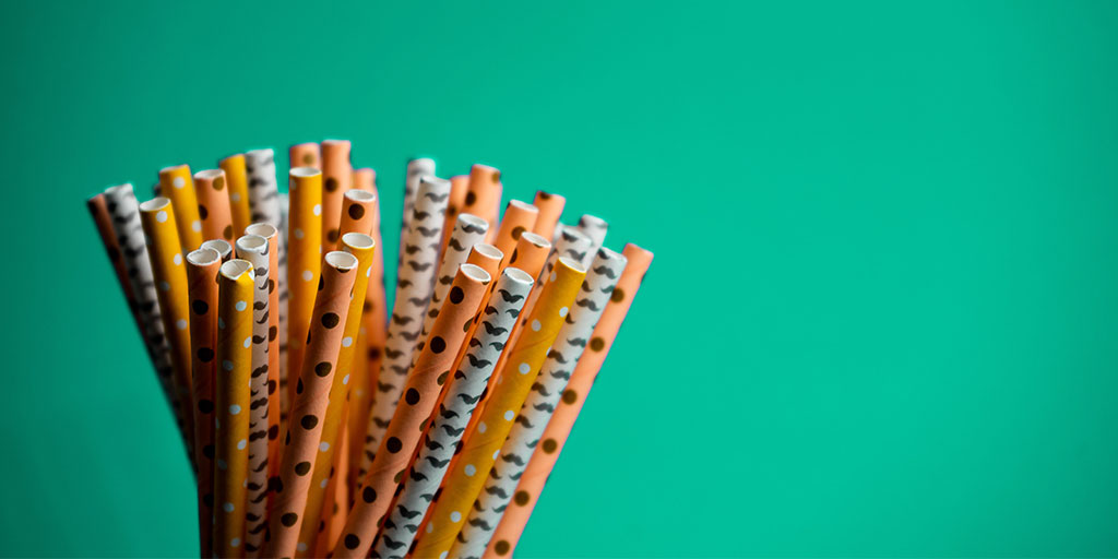 B bunch of paper straws with different designs on them including spots and moustaches.