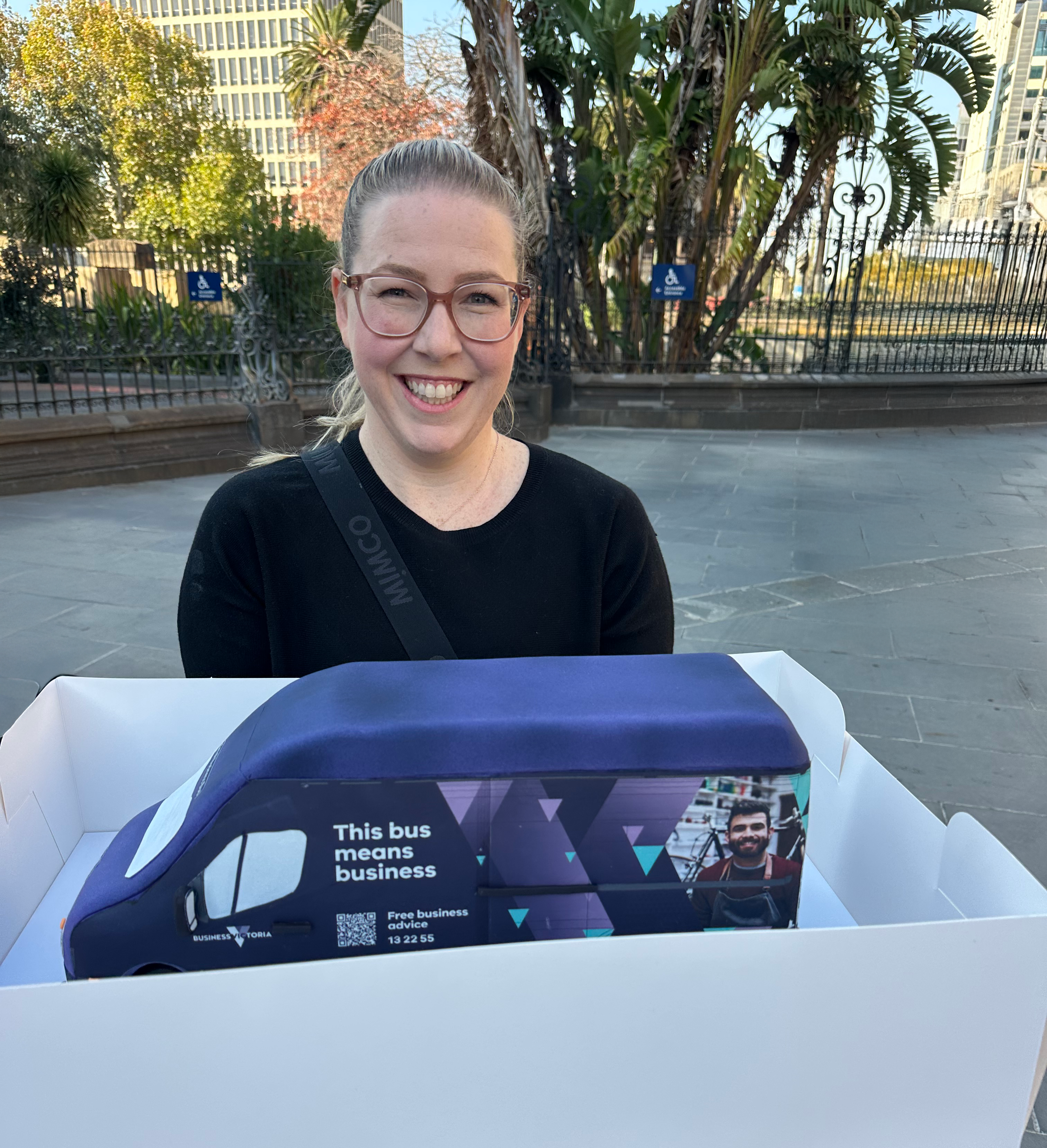 a blonde lady with a bus-shaped cake