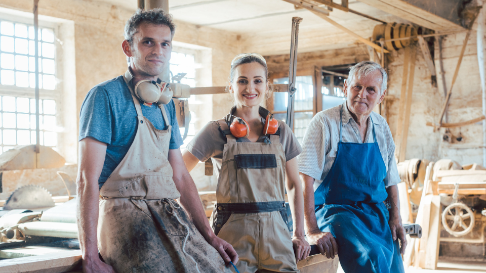 Three people in a carpenter's workshop 