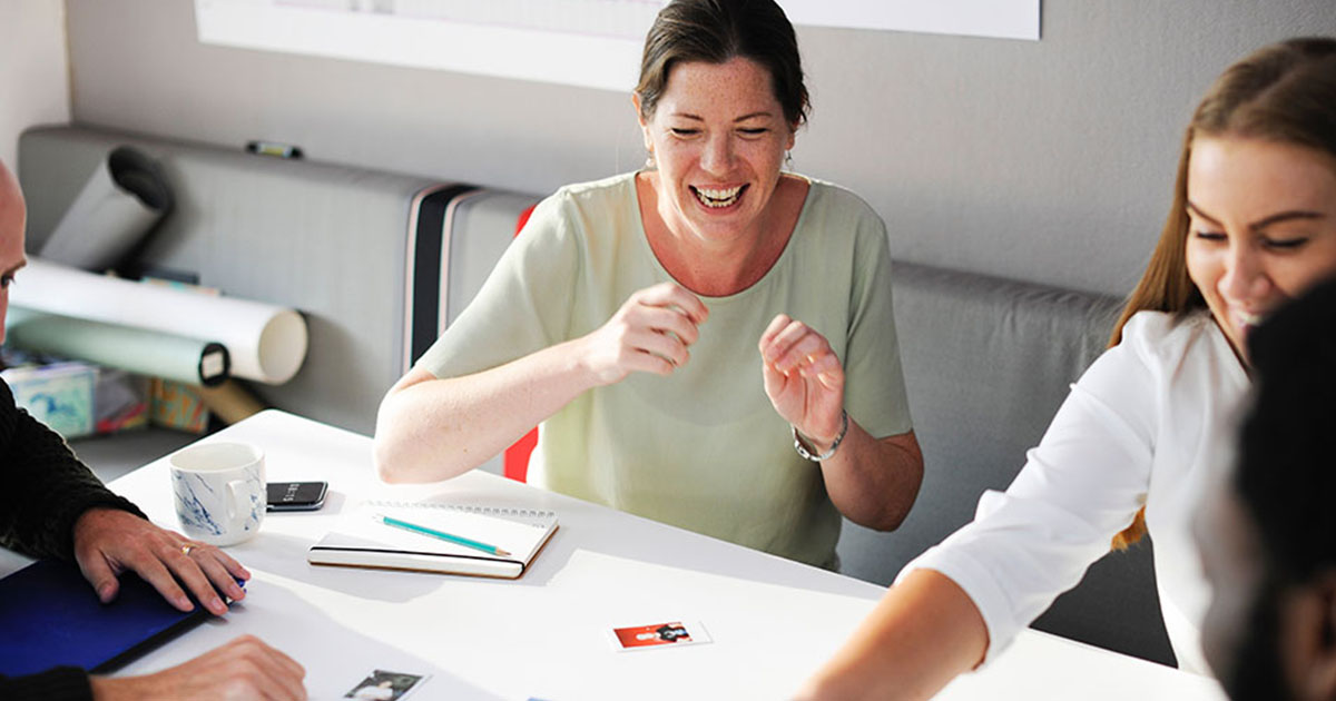 Smiling people work at a table together.