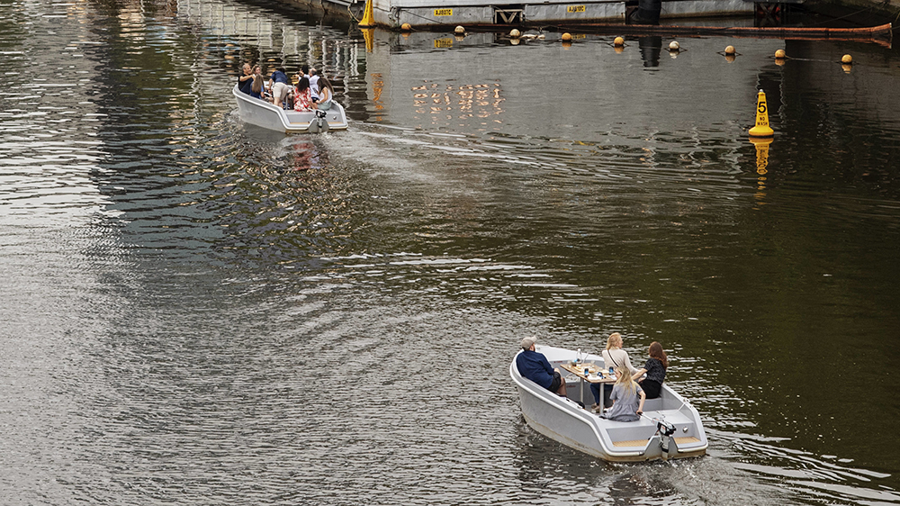 Two motor boats cruise along the Yarra River in Melbourne.