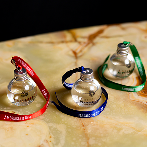Gingle Bells gin filled Christmas baubles resting on a kitchen bench. Each bauble has a different coloured ribbon.