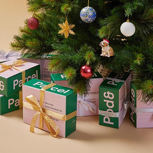 Several boxes under a Christmas tree with the words ‘parcel’ on the side.