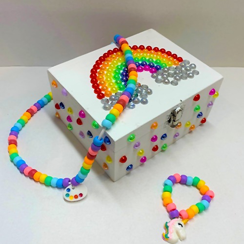 A jewellery box from Merryl's Mosaics. It is decorated in colourful beads to make a rainbow.