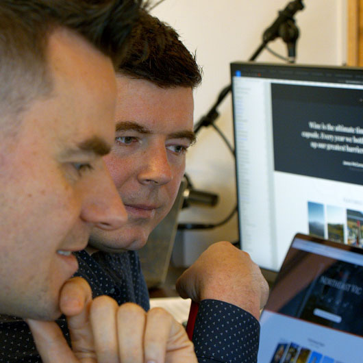 A close up of two men looking at computer screens.