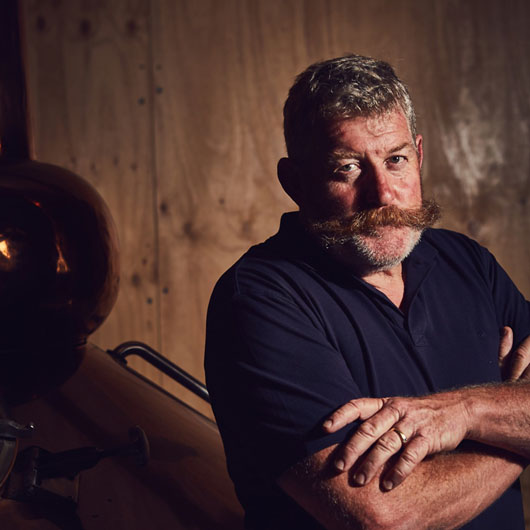 The owner of Bellarine Distillery with his arms crossed looking at the camera.