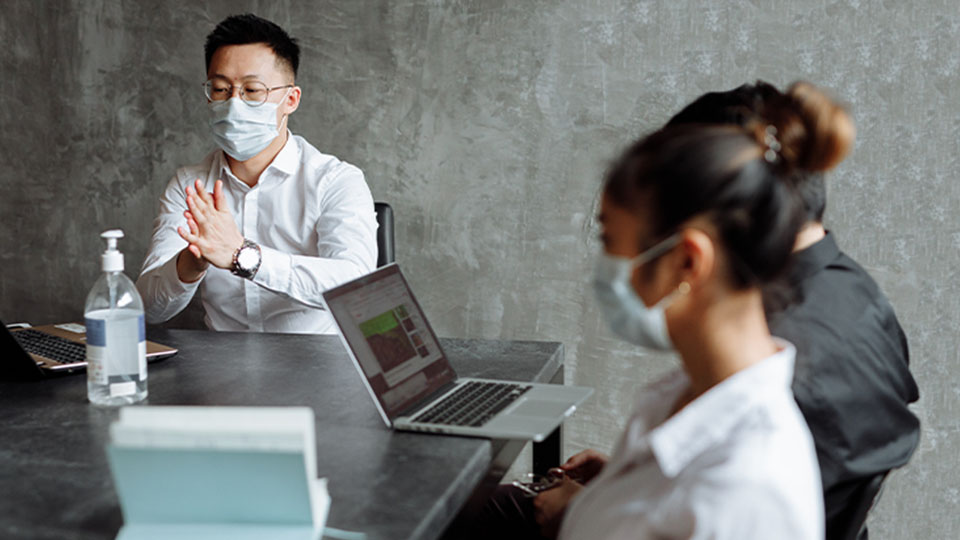 Three business people sitting around a table in a meeting room