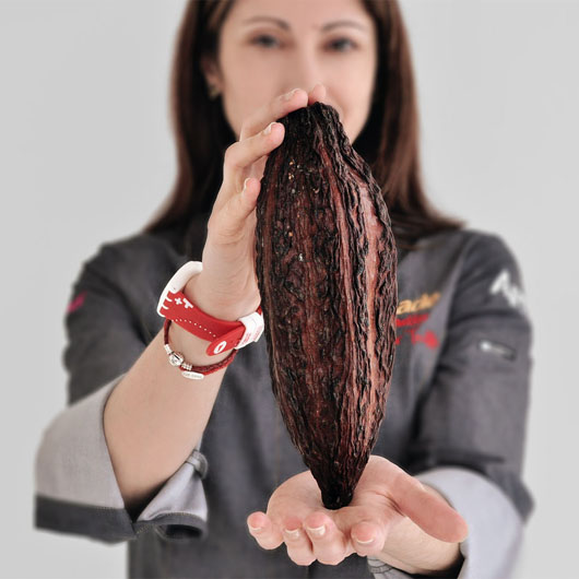 A woman holding a cacao pod. 